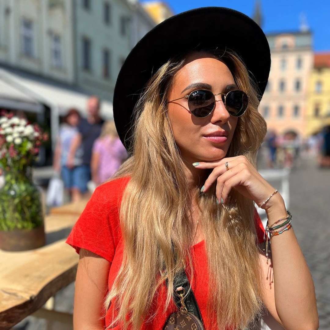 Woman wearing sunglasses a Matilda Gira hat in Ceske Budejovice